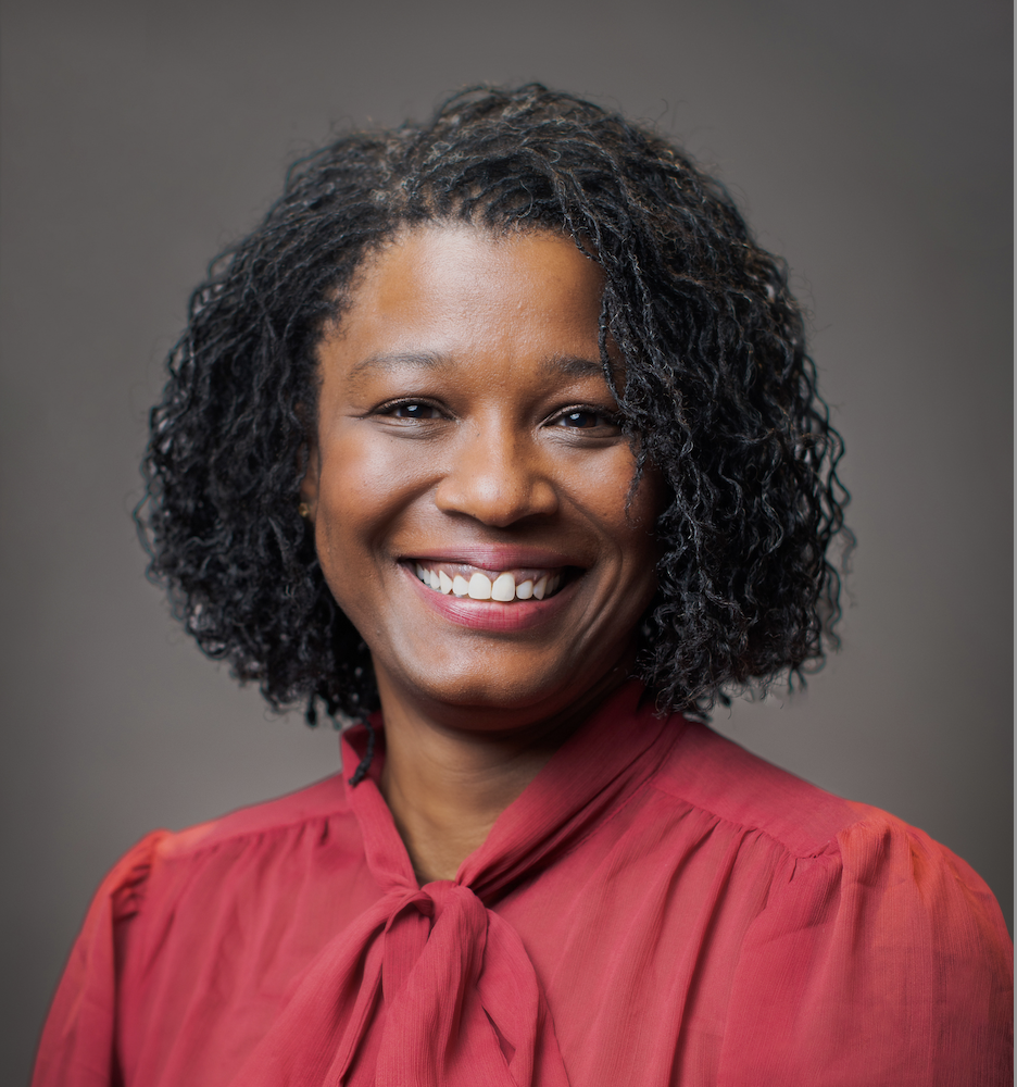 Black woman in red shirt posing for a headshot.