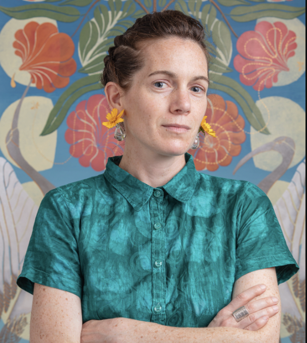 Woman posing for a headshot in a green dress.
