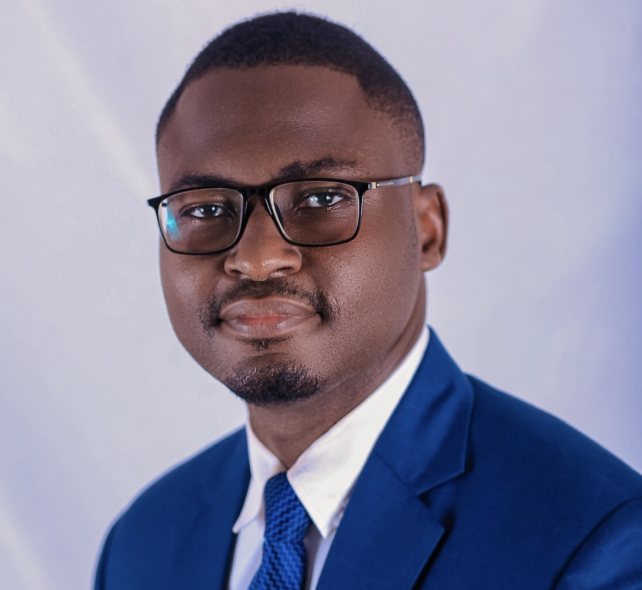 Black man in a suit and tie posing for a headshot