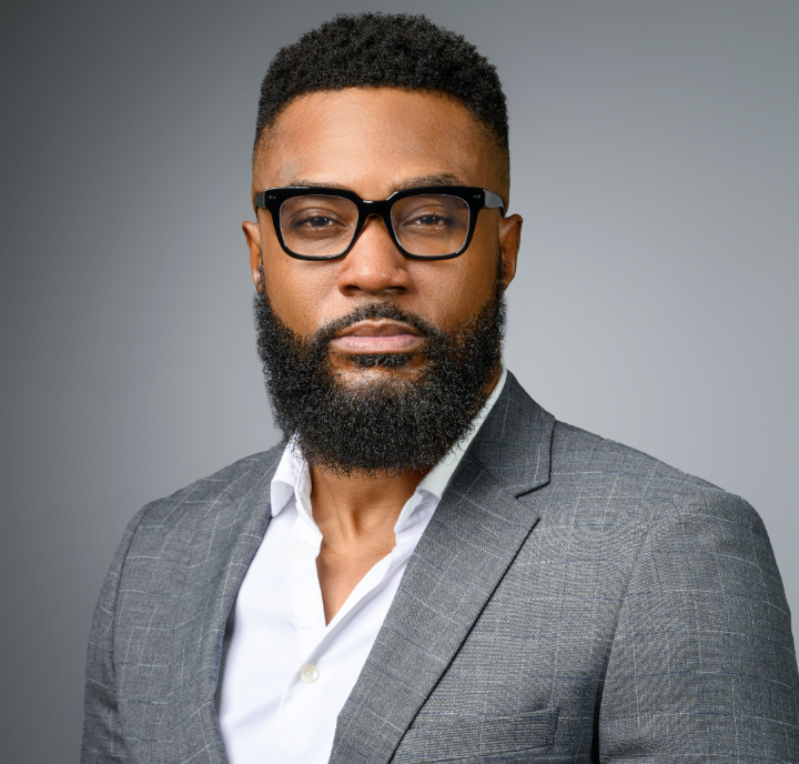 Man in a gray jacket posing for a headshot