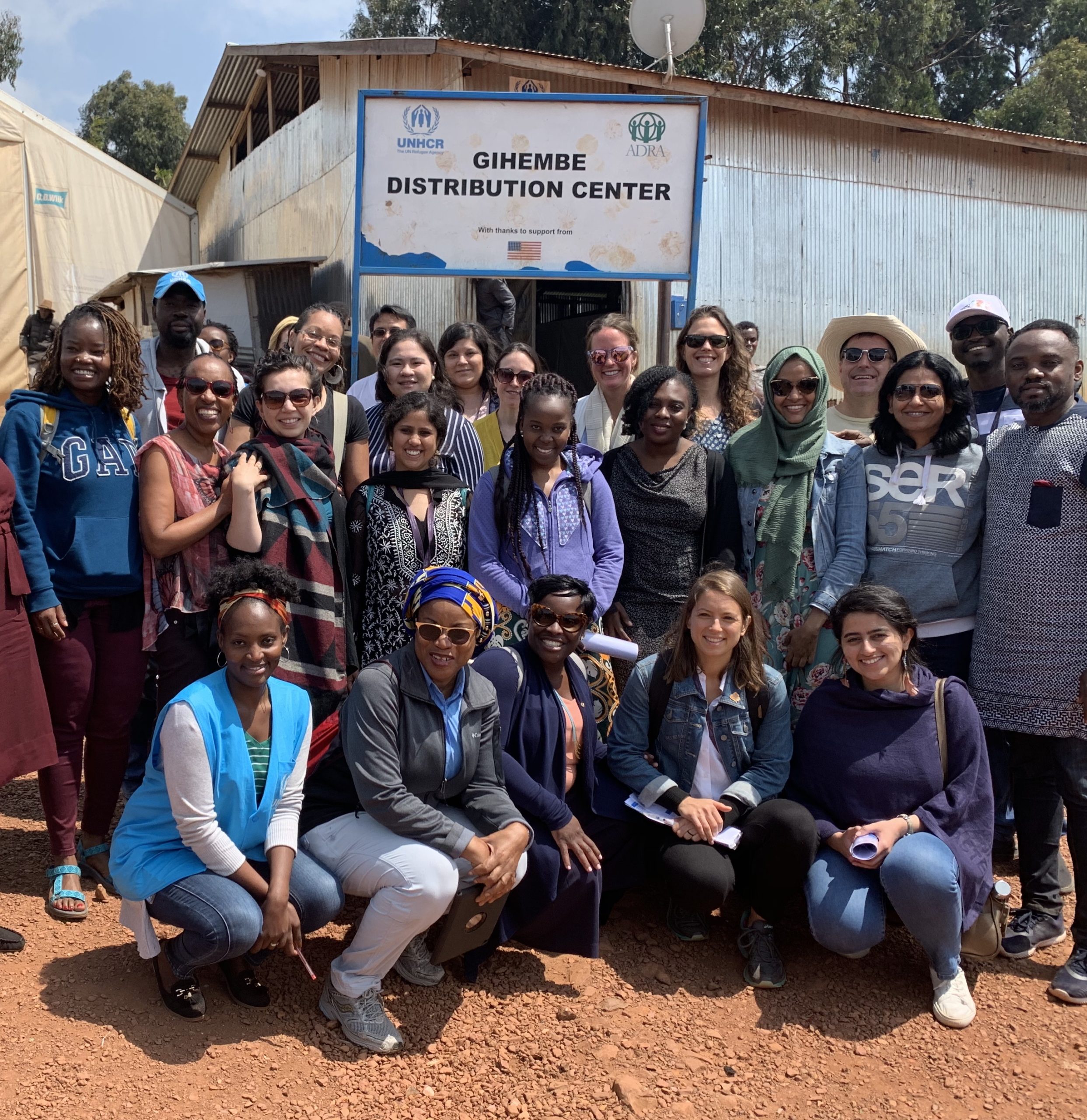 Group of fellows in front of a sign in Rwanda, Africa