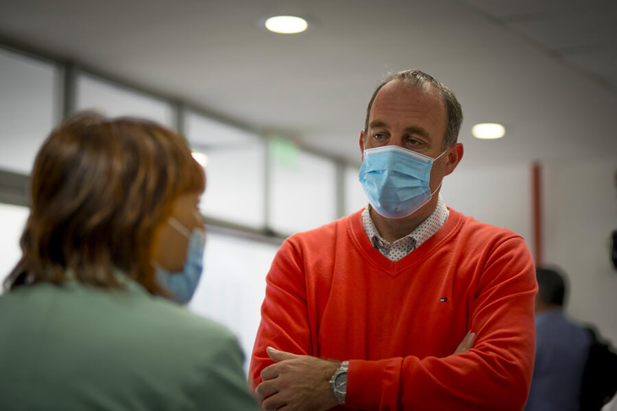 man in mask talking to woman