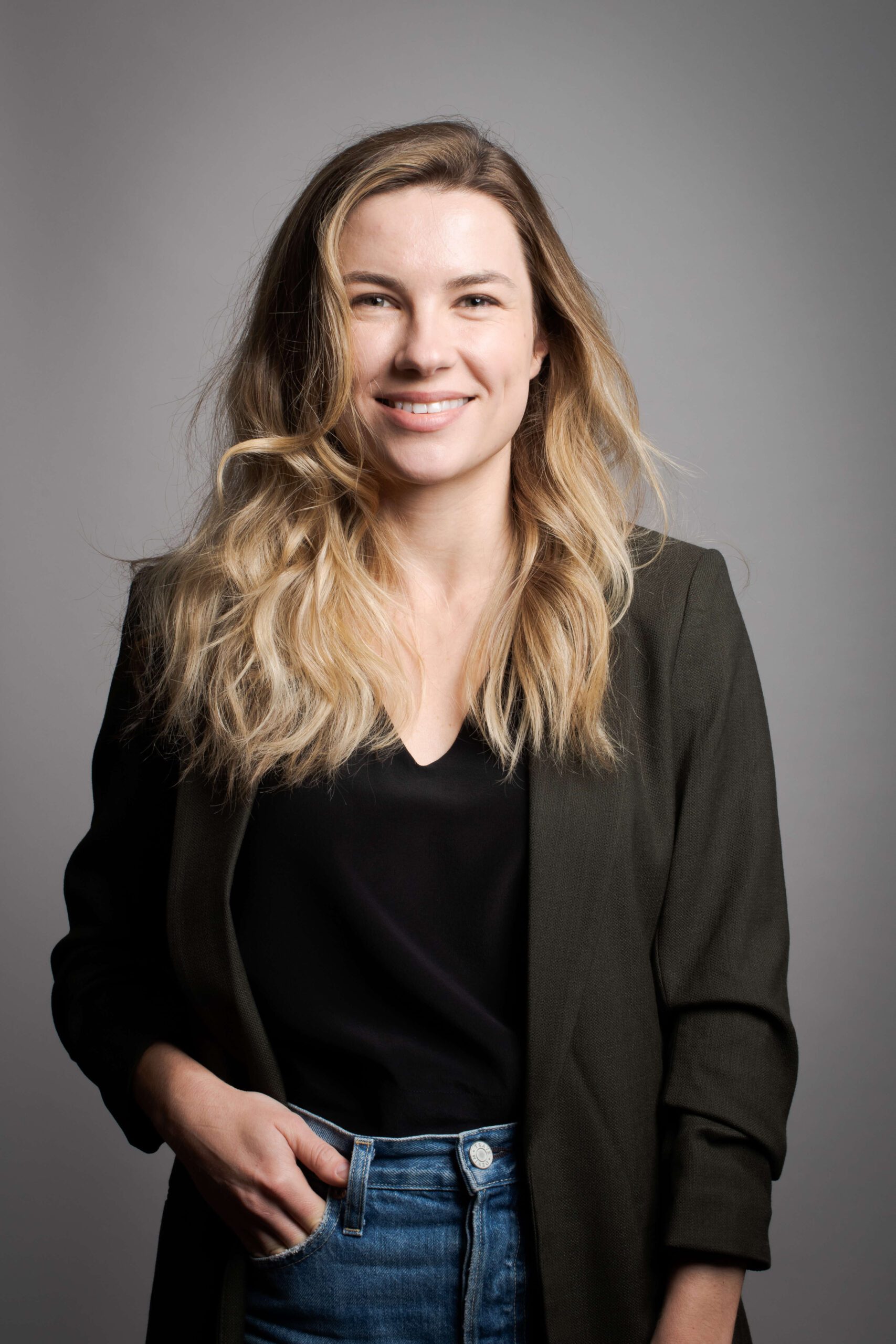 Woman smiling with hand in her pocket