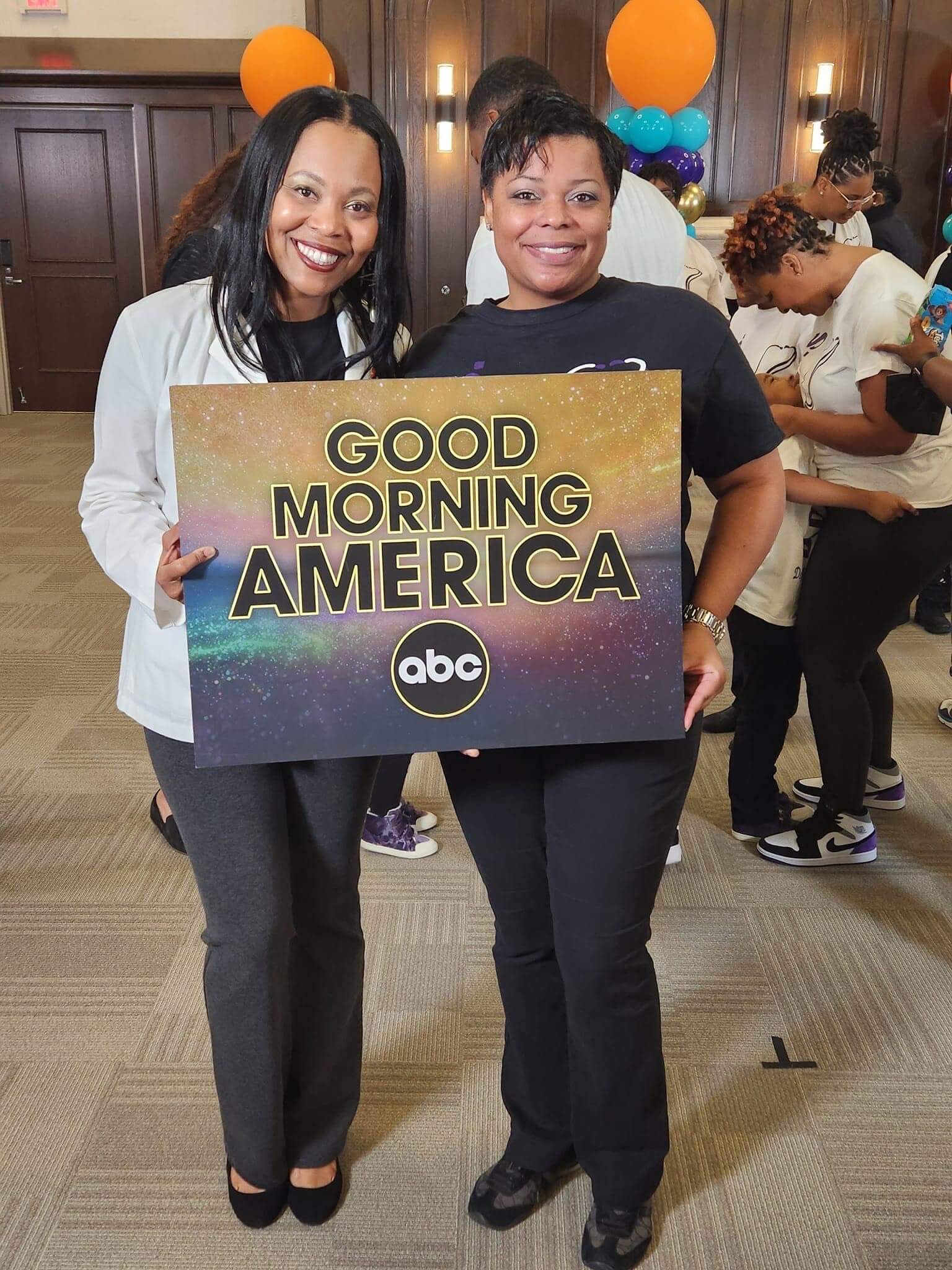 Two men holding a Good Morning America sign.