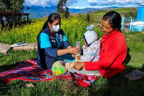 A mother, her child and a community health worker in Peru