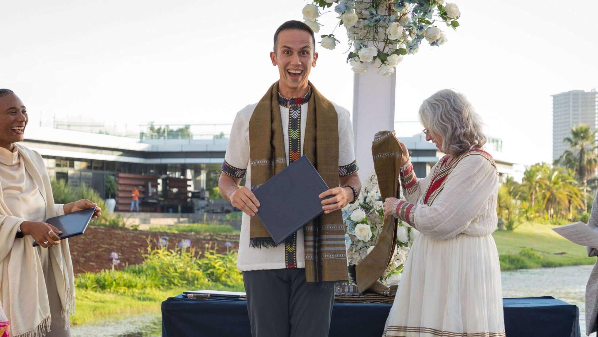 Man holding a certificate on stage.