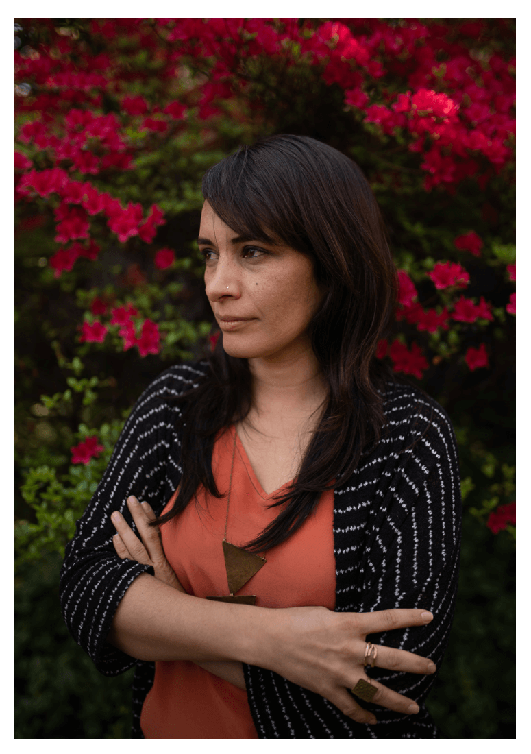 Woman posing in front of flower bushes