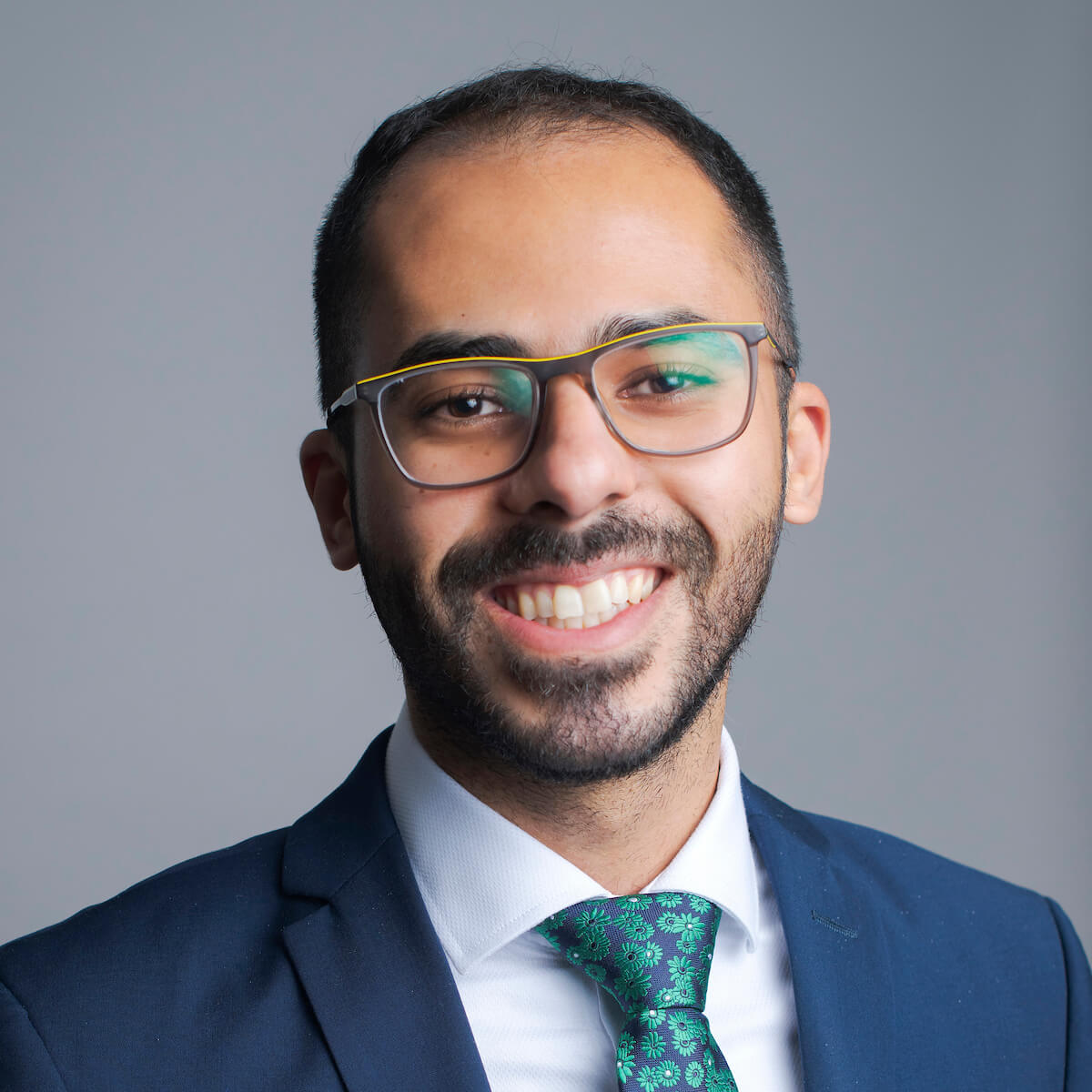 Man with glasses posing for a headshot.
