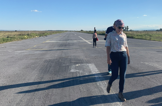 Woman walking down an empty road.