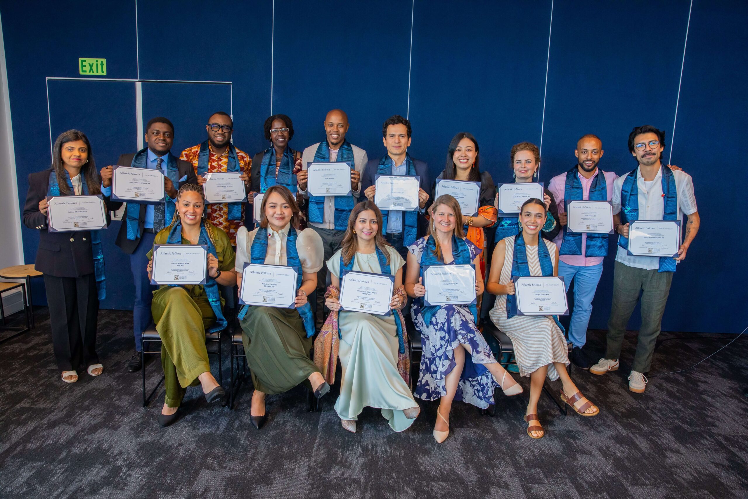 Group of people posing for a picture with graduation certificates in their hands.