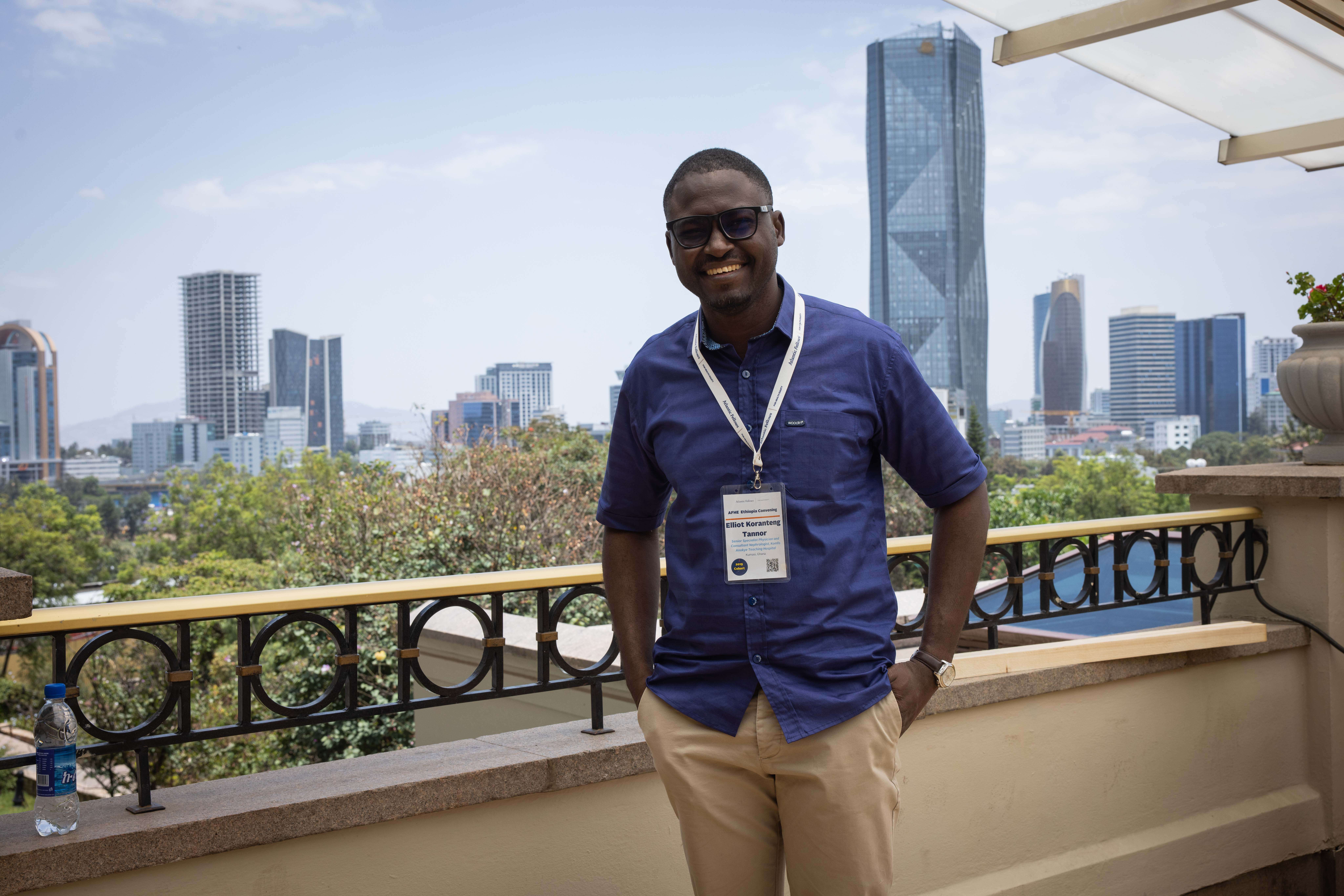 Man posing for a picture in front of a skyline.