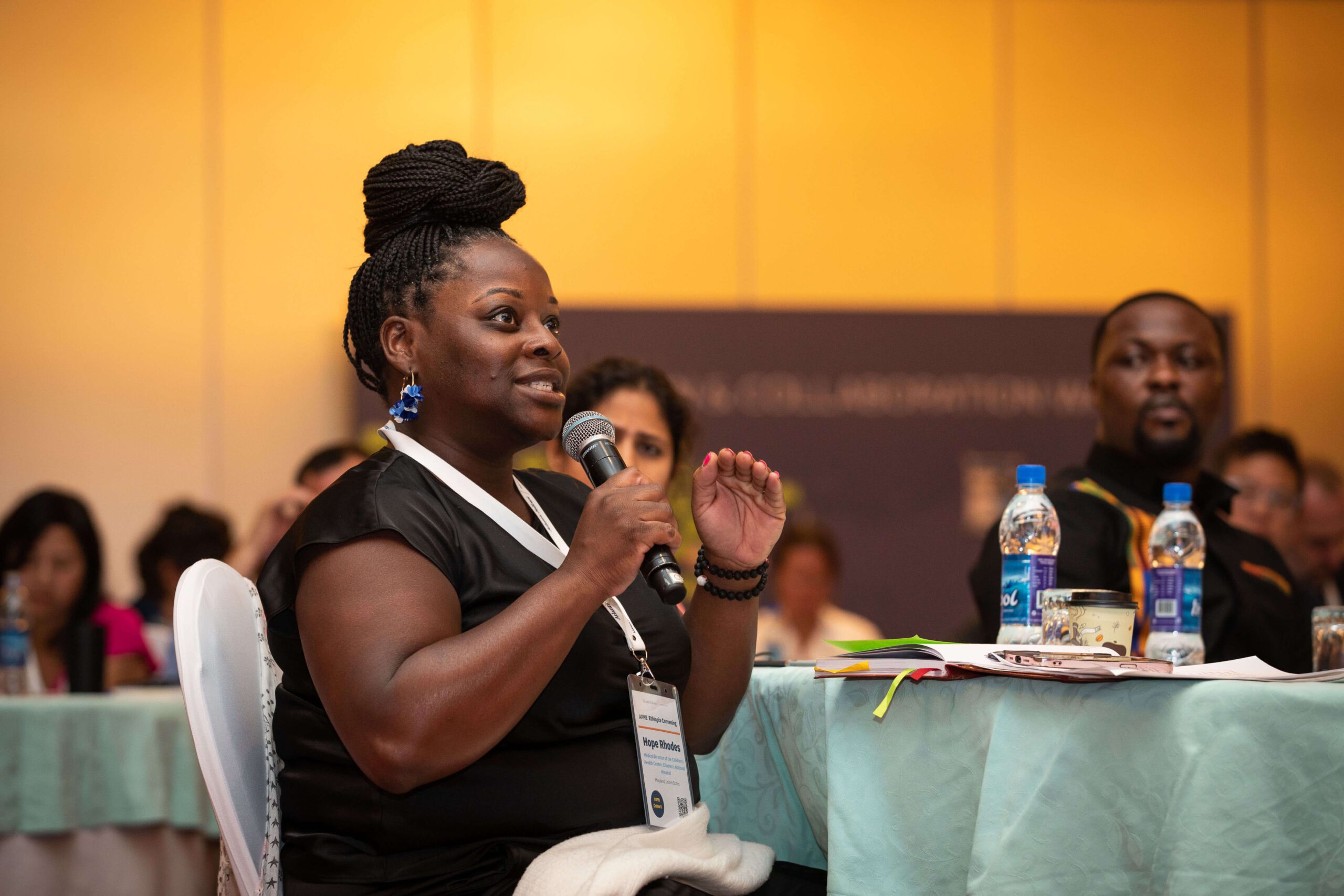 Woman sitting down and speaking into a microphone