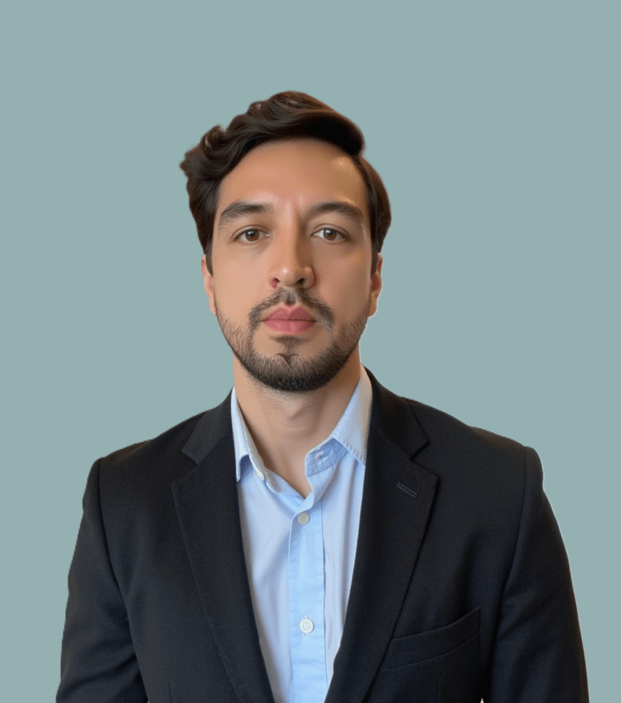 Man posing for a headshot in front of a teal/gray background