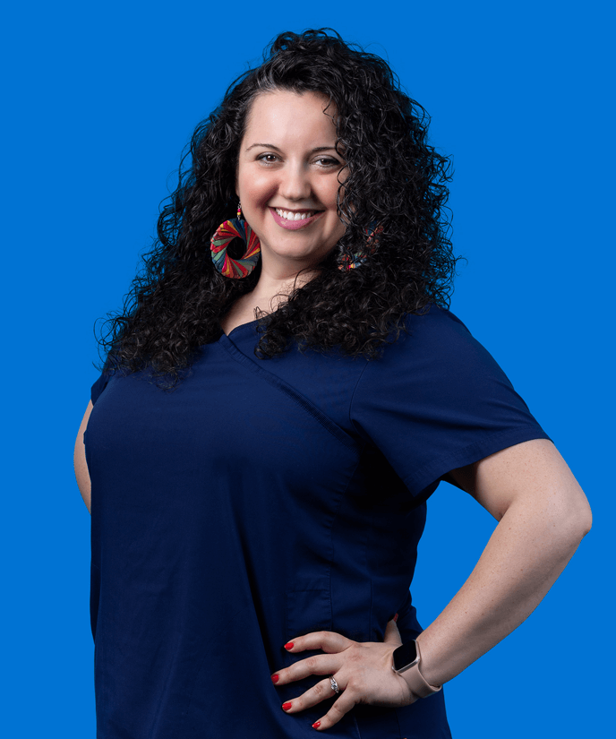 Woman in dark blue shirt posing in front of a bright blue background