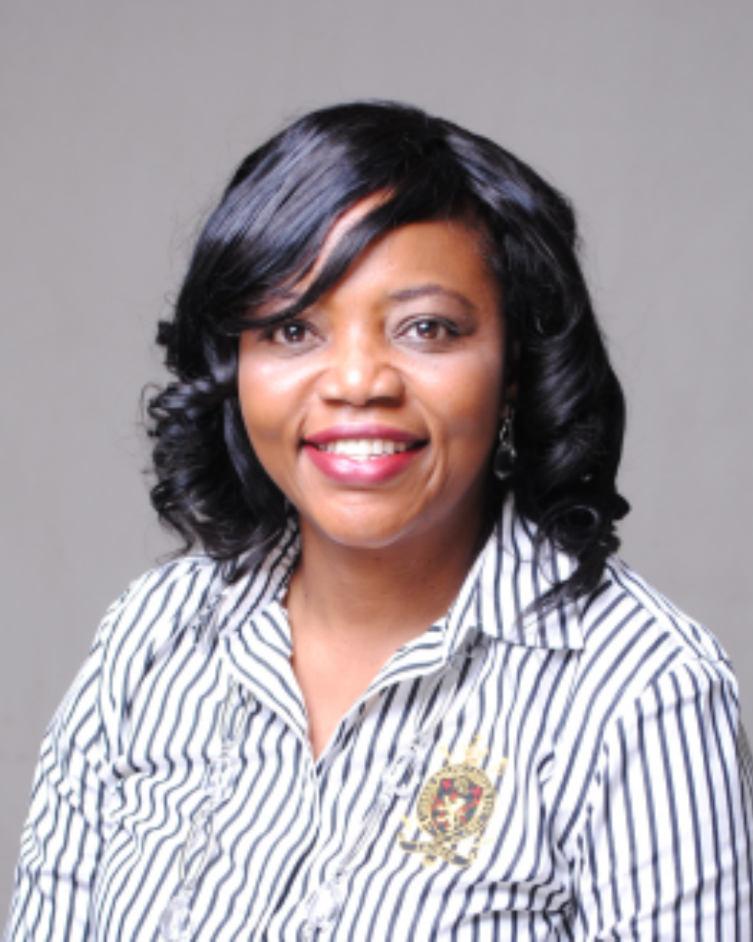 Woman posing for a headshot against a gray background