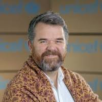 man with a beard and sweater posing for a headshot