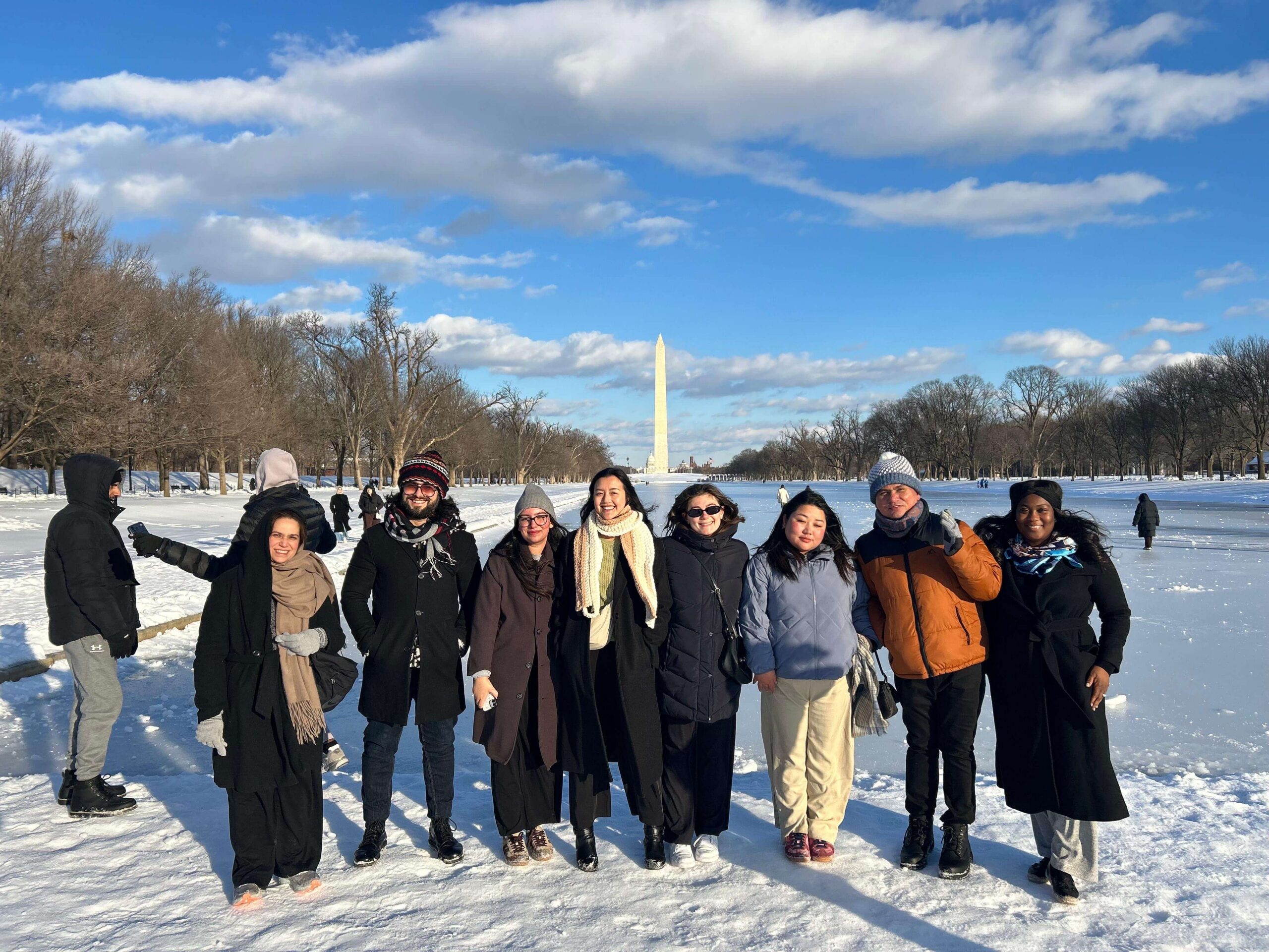 Group picture of people outside in the snow with washington monument in the background