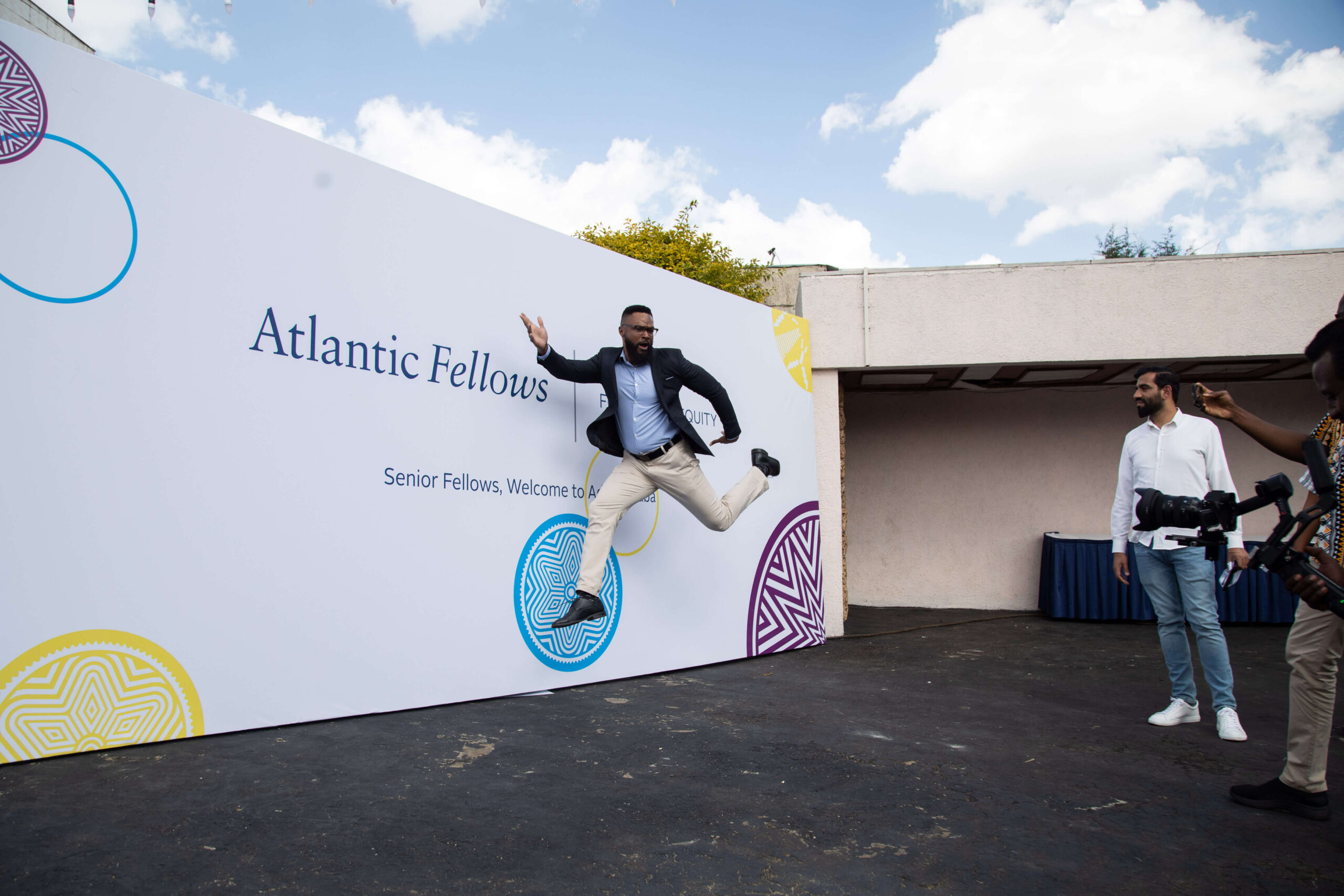 man jumping in front of a step and repeat