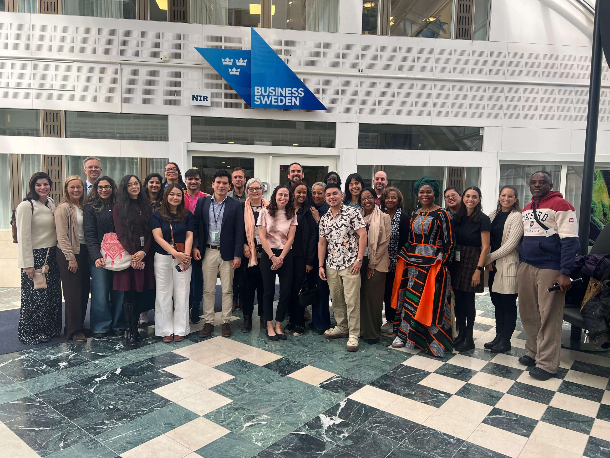 Group of diverse people in front of a Business Sweden sign.