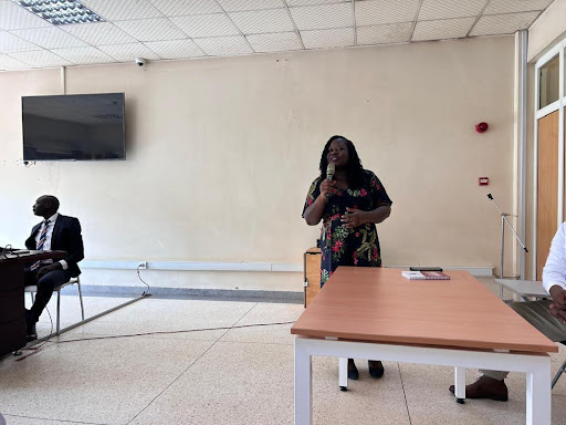 woman standing behind a table talking into a microphone