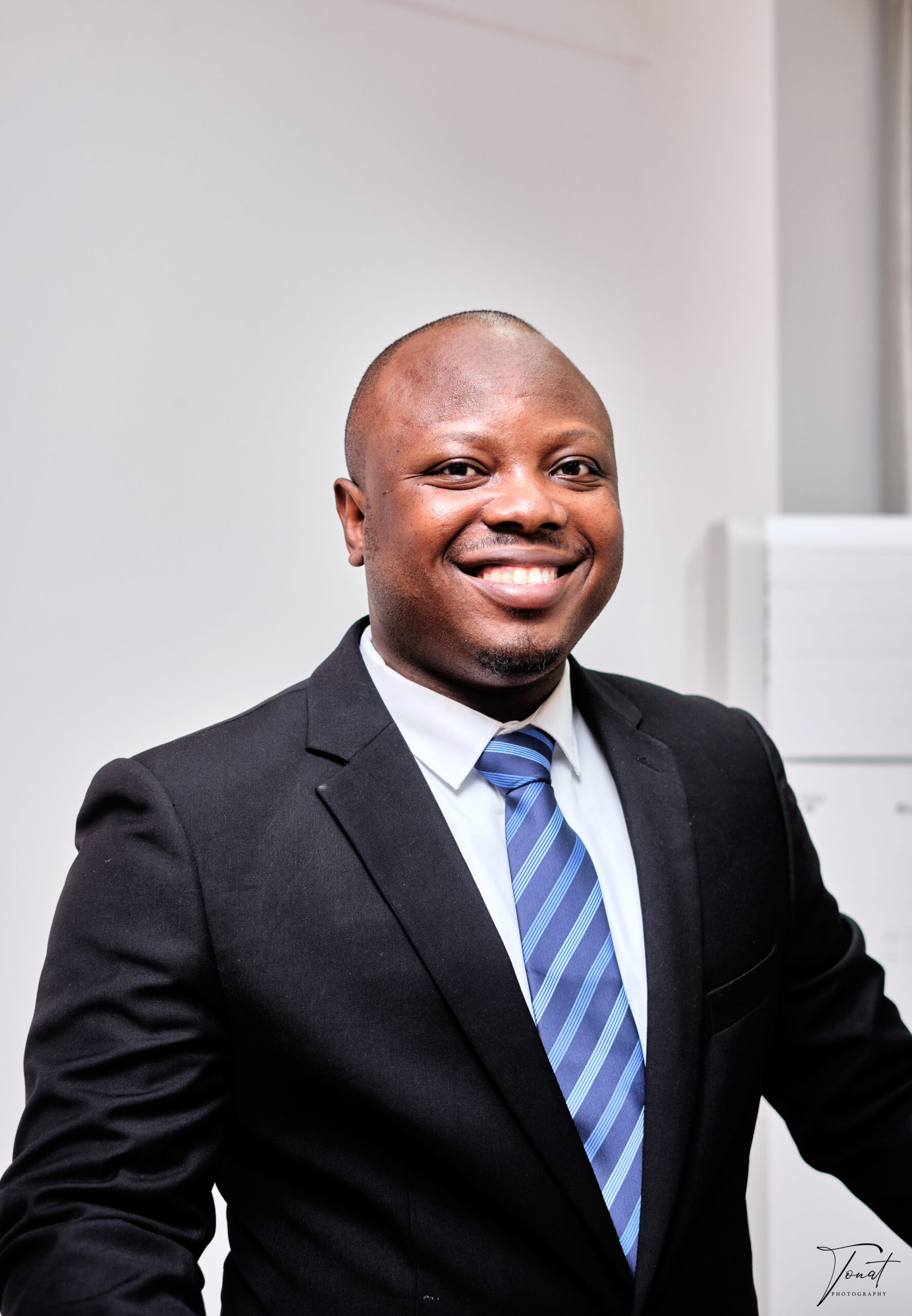 Black man in a suit, posing for a headshot.