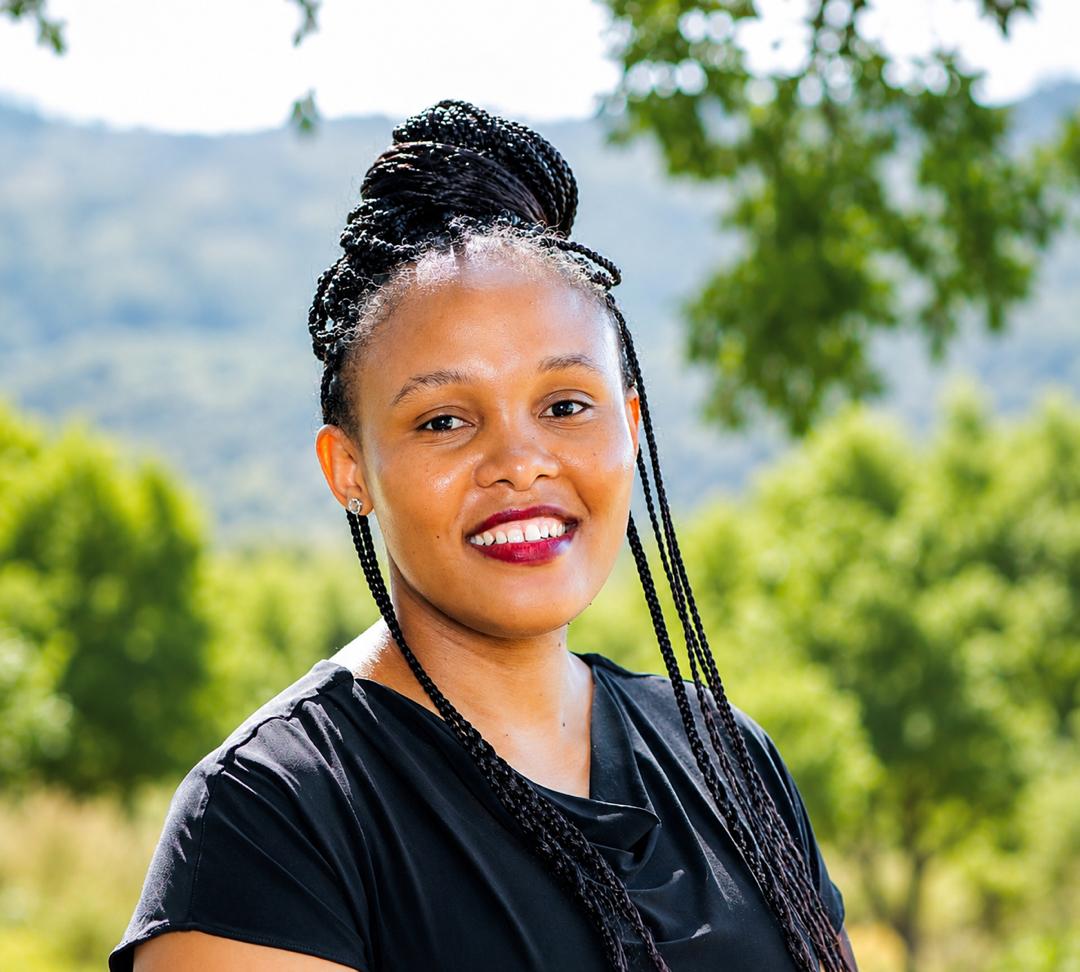 Woman posing for a headshot in outdoor setting.