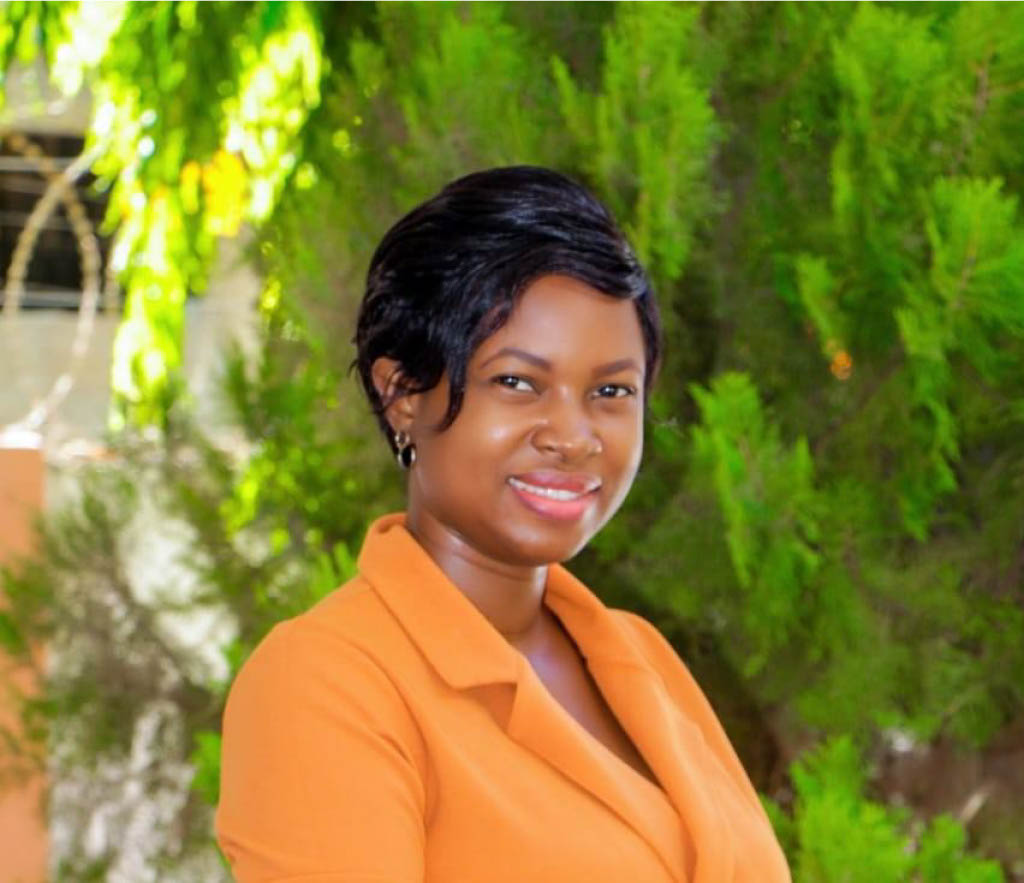 Woman posing for a headshot in front of a tree.