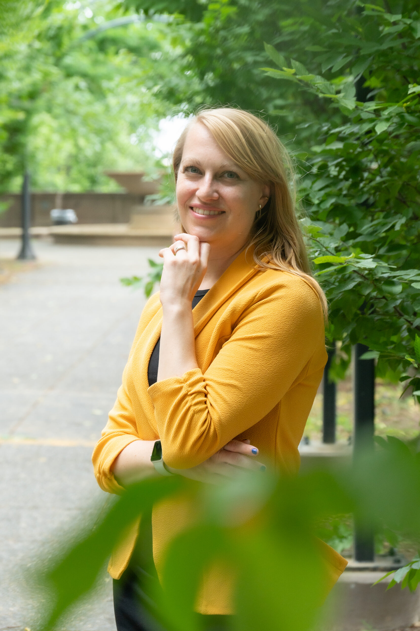 Woman posing for a headshot in a park.