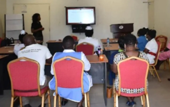 People in red chairs looking at a screen